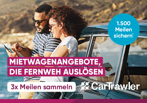 Ein Paar lehnt an einem Auto und schaut auf ein Smartphone.